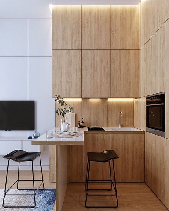 a minimalist kitchen with sleek plywood cabinets, a countertop for eating and cooking and leather stools