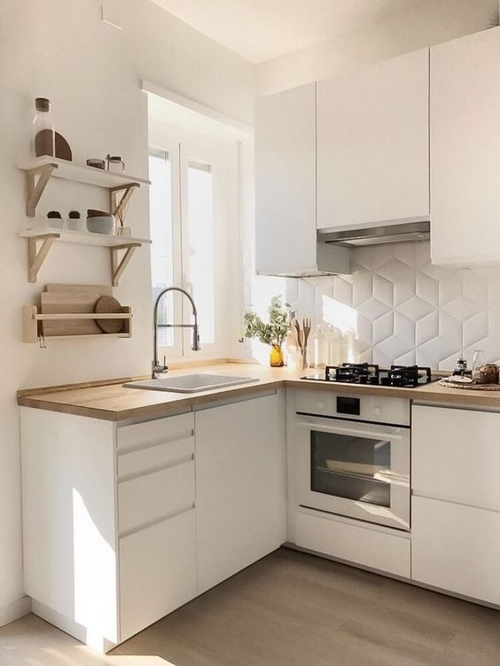 a small minimalist kitchen with sleek white cabinets, light stained wooden countertops, a white tile backsplash, open shelves