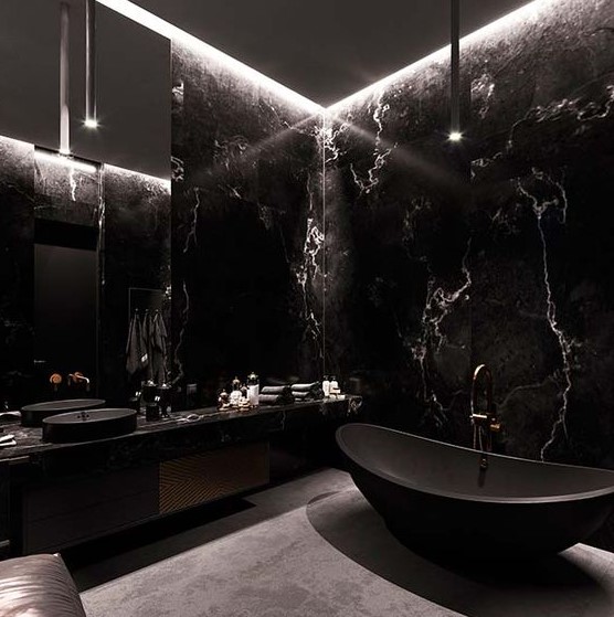 a stunning black masculine bathroom done with black marble, a matte black bathtub and a floating vanity