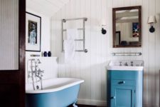 a vanity and a clawfoot bathtub done in blue add a touch of chic color and make the space catchy