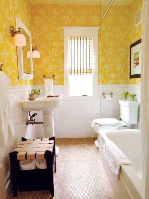 a vintage bathroom with yellow floral wallpaper, white paneling, white appliances, a woven pouf and potted greenery