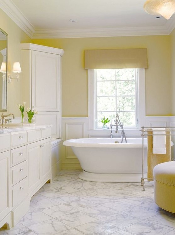 A vintage lemon infused bathroom with light yellow walls, lemon furniture and textiles and all white around looks warming