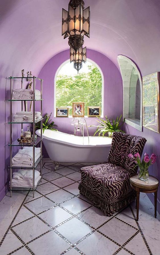 a whimsy lavender bathroom with a Mediterranean feel, unique pendant lamps, a zebra print chair and a catchy glass etagere