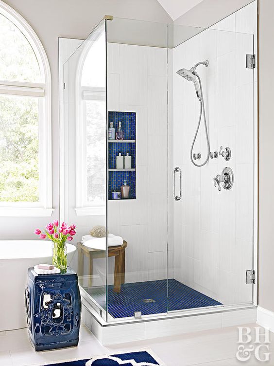 bright blue tile touches - shower floors, a niche for storage and an elegant side table