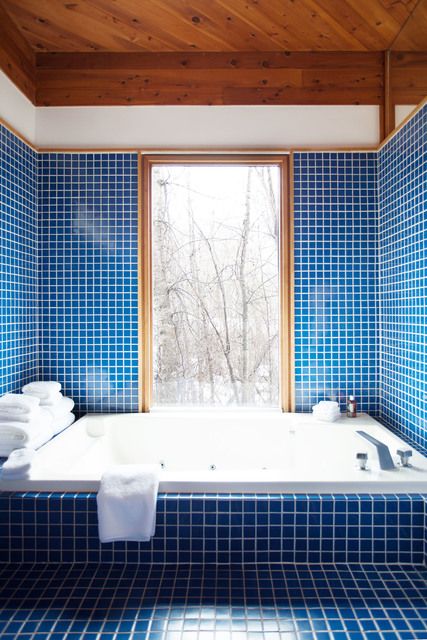 bright blue tiles with white grout all over the bathroom plus light-colored wooden frames and ceilings