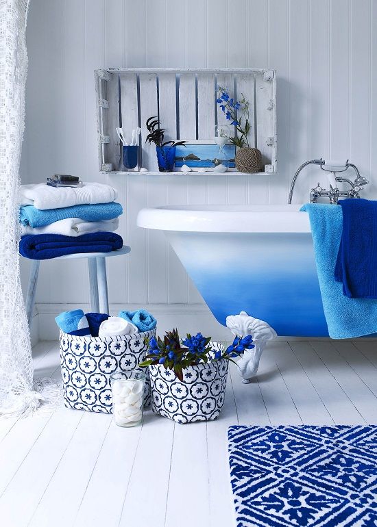 bright blue touches - a rug, towels, fabric baskets and a bright ombre blue clawfoot bathtub for a chic space