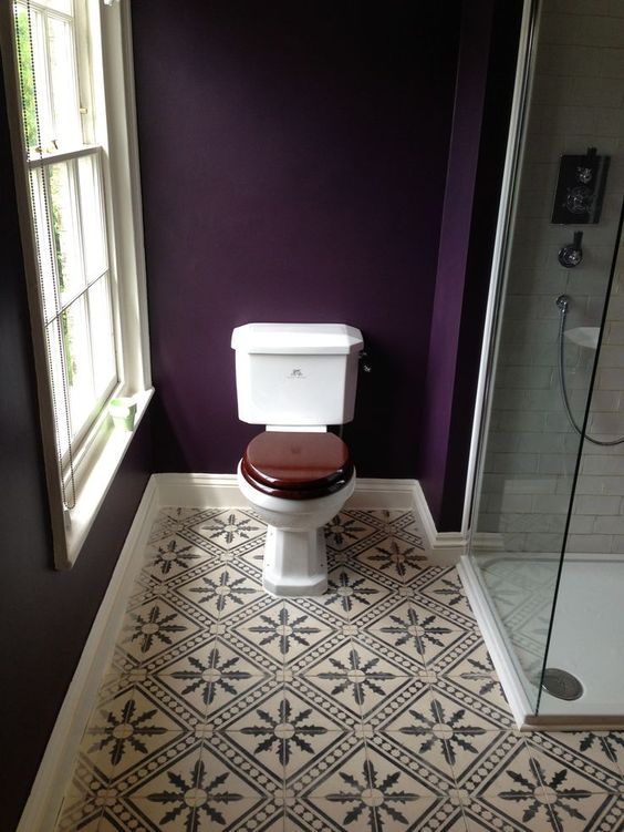deep purple walls and mosaic tiles on the floor make this bathroom elegant, chic and very decadent