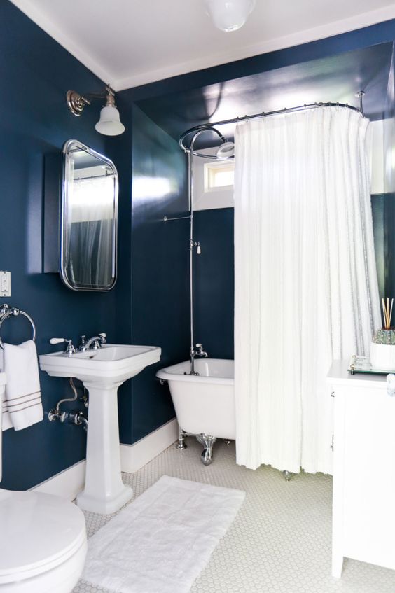 navy painted walls paired with all the rest in creamy shades is a chic idea to create a bold bathing space
