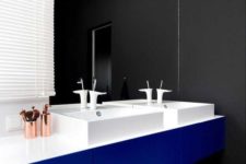 this modern master bathroom features black and white striped flooring, a black wall, and a bright blue vanity