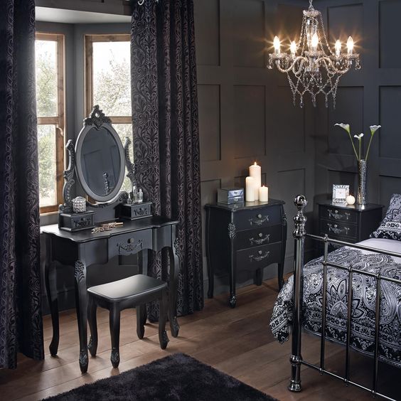 a Gothic space with graphite grey paneling, refined furniture, a forged bed, a crystal chandelier and dark linens