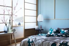 a beautiful zen-like bedroom with traditional Japanese sliding doors, a low bed and wooden furniture, blue walls and a ceiling, floral bedding