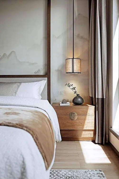 a chic neutral bedroom with mountain panels on the walls, a wooden nightstand and an upholstered bed, pendant lamps and color block curtains