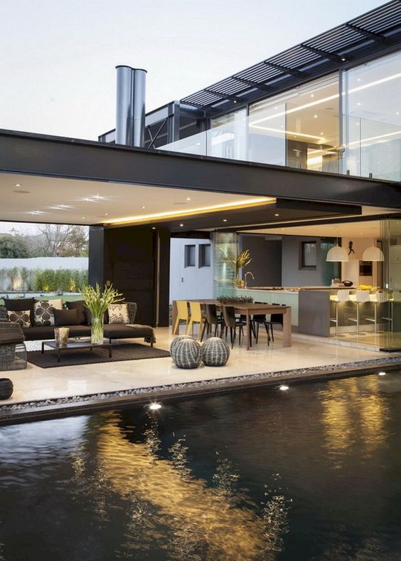 A modern terrace by the pool, a living room space and a dining zone plus built in lights