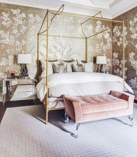 a romantic glam bedroom with botanical print walls, a glam gold bed, a pink bench, mirror nightstands