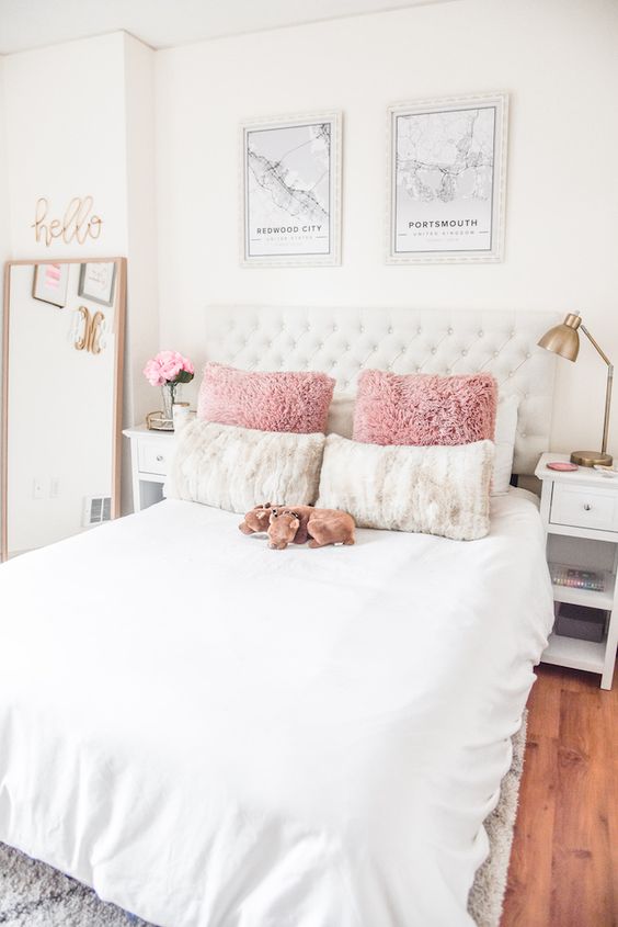 a simple glam bedroom with touches of brass, a white bed, some art and calligraphy for a teen
