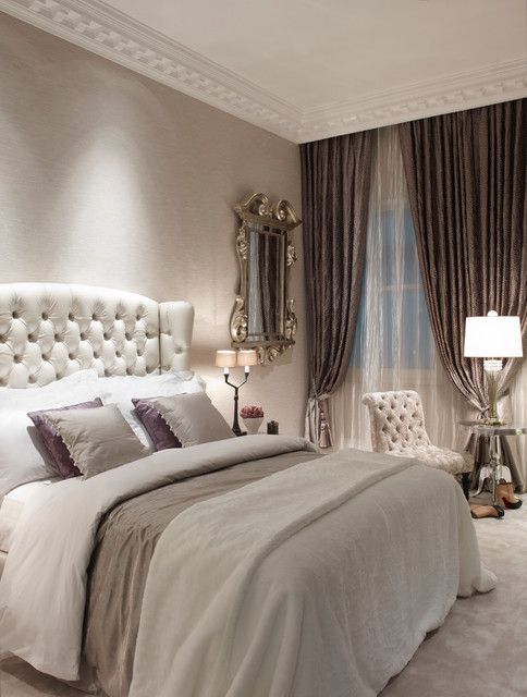 a vintage glam bedroom with a white leather bed and chair, mirror furniture, a vintage mirror and lilac touches