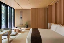 a zen bedroom with low wooden furniture, wooden screens, a glazed wall and some statement plants and artworks