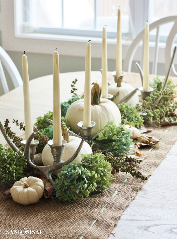 Dried hydrangea, birch bark and candelabras are a great company to white pumpkins on a natural-looking burlap table runner.