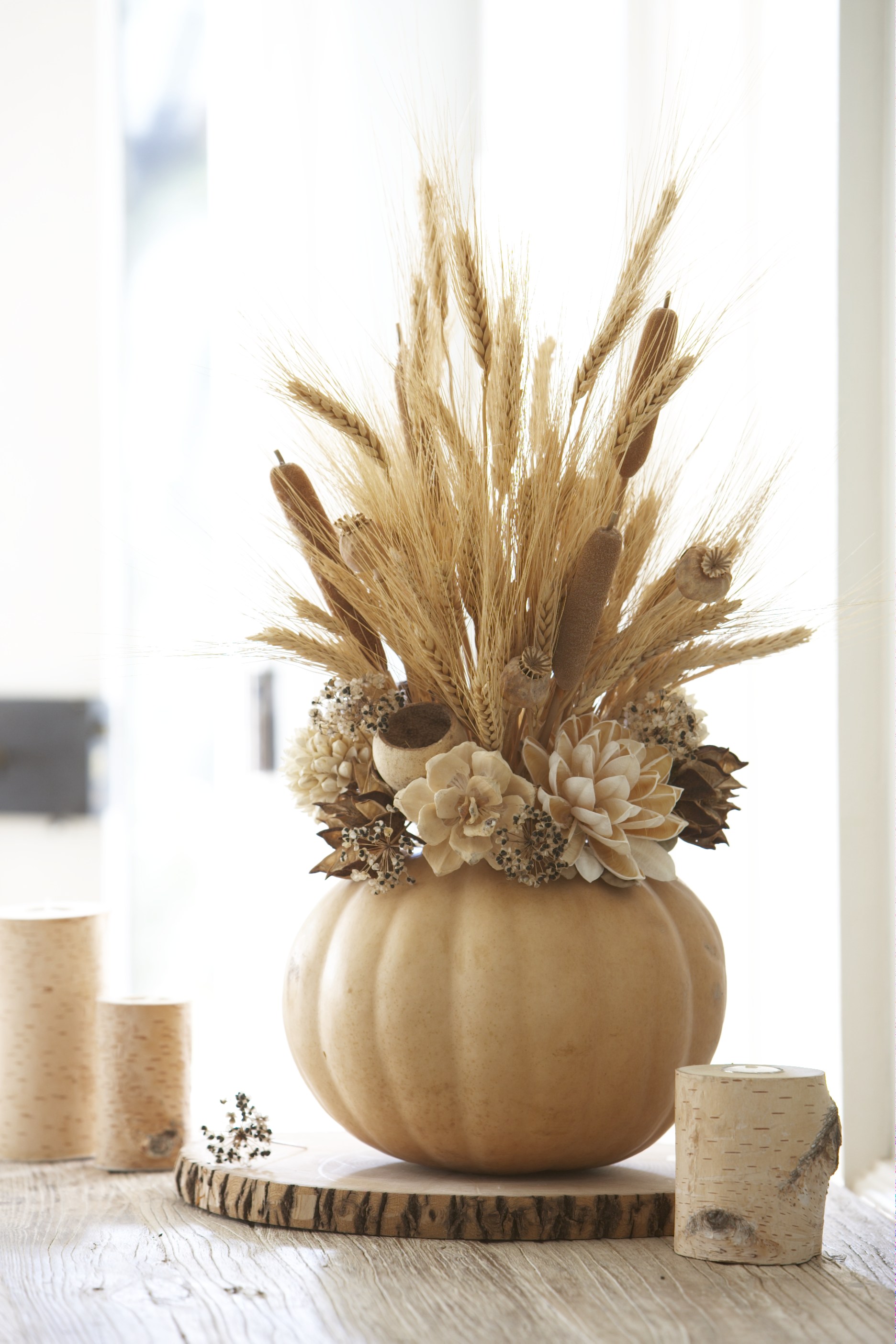 Dried wheat stems and faux flowers in beige and brown tones could be perfect additions to a subtle, natural looking Fall centerpiece.