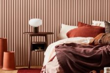a bold fall-colored bedroom done with a palette of chocolate brown, rust, burgundy and deep red