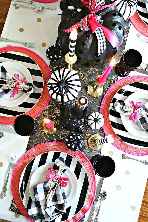 a bold modern Halloween tablescape with hot pink touches, black, white and gold and painted pumpkins