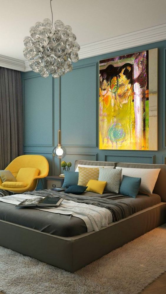 a colorful fall bedroom with a bright artwork, a yellow chair and pillow and lots of teal