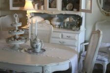 a gorgeous shabby chic dining room with shabby chic furniture, an elegant buffet, a crystal chandelier and chic porcelain