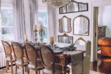 a jaw-dropping French chic dining room with a stained vintage table, vintage chairs, a gallery wall of mirrors and a crystal chandelier
