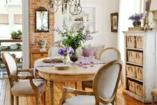 a lovely neutral French chic dining room with an oval table and vintage chairs, a neutral storage unit with baskets, a lovely wall-mounted unit