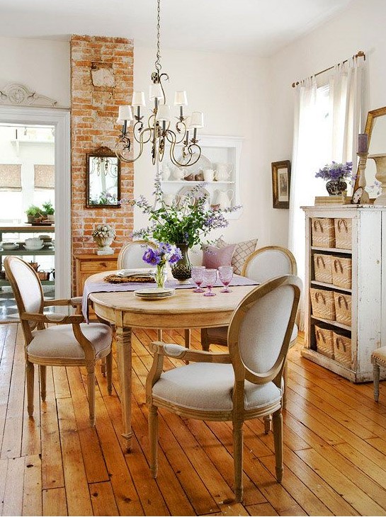 A lovely neutral French chic dining room with an oval table and vintage chairs, a neutral storage unit with baskets, a lovely wall mounted unit