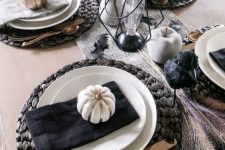 a modern rustic Halloween tablescape with woven placemats, painted apples and pears, candles and bulb lamps