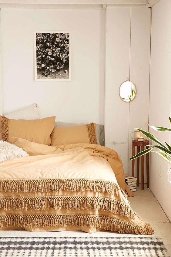 a neutral fall bedroom done in creamy, greys and touches of beige plus boho details