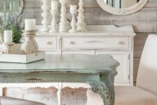 a shabby chic meets rustic dining room with rough wooden walls, a gallery wall with mirrors and art, a mint-colored table and candles
