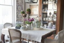 a vintage French dining space with a stained buffet, wall-mounted shelves, a vintage dining table and vintage chairs
