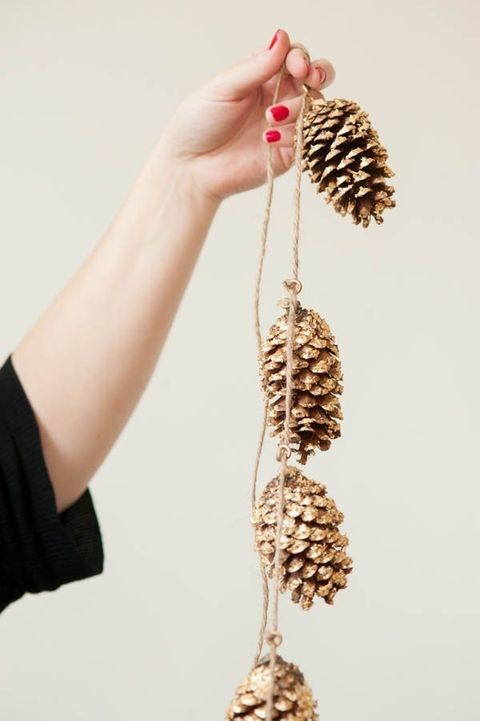 Gold glitter spray paint is a good way to make your pinecone garland shiny.