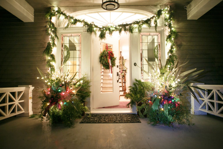 Disguise unsightly wires from string lights by winding them around a column or post with Christmas greenery.
