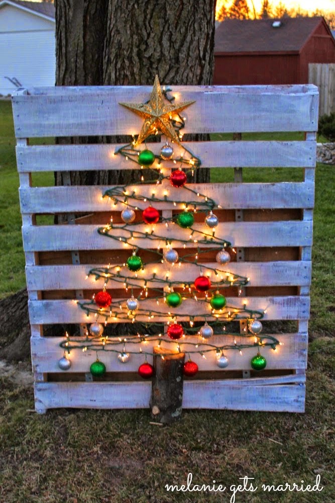This DIY Christmas tree is made by putting nails on a pallet and stringing lights and ornaments along them.