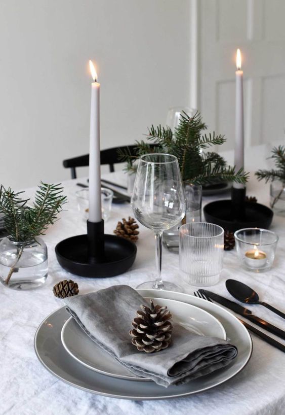 a Nordic Christmas table with neutral linens, white candles, pinecones, evergreens for a cozy Christmas dinner