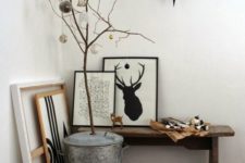 a Nordic entryway space with some artworks, branches with ornaments and a large black star on the wall