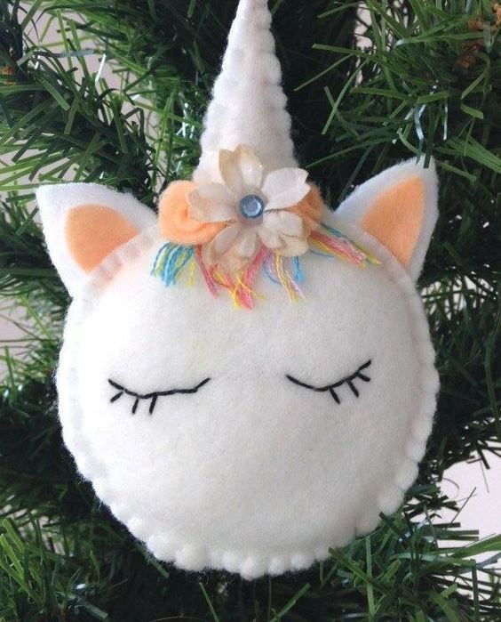 a beautiful unicorn Christmas ornament with colorful yarn, beads and a fabric bloom is amazing