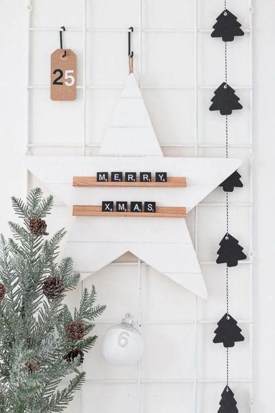 a black Christmas tree garland, a pale tree with pinecones and a star with scrabble letters