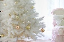 a medium size white Christmas tree with gold and copper ornaments looks glam and shiny