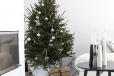 a minimalist Christmas tree with sheer and metallic ornaments and white and black candleholders