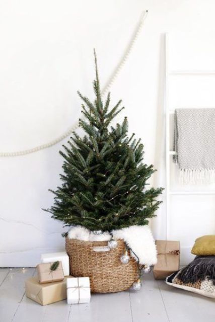 a minimalist Nordic Christmas tree with lights, white fur and bulbs plus gift boxes