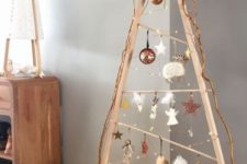 a modern framed Scandinavian Christmas tree with lights, white and copper ornaments and glam gift boxes