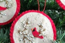 a red and white round Christmas ornament with beads and a bird applique is a bold and chic idea to rock