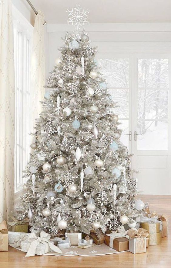 a silver Christmas tree with white, silver and blue ornaments, rhinestone snowlakes and some lights