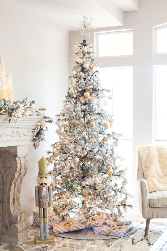 a silver tree with a snowflake topper pastel and yellow ornaments looks refined