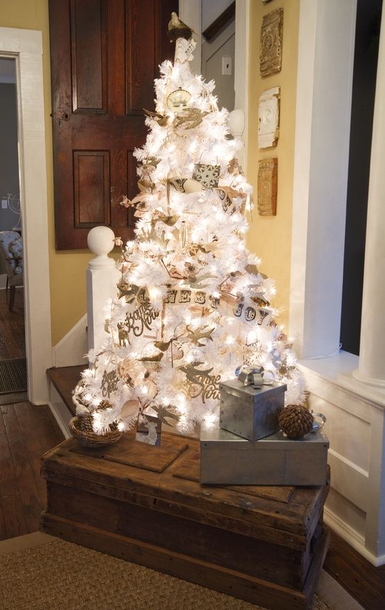 a white Christmas tree with lights decorated with vintage-inspired ornaments and paper buntings is very cool