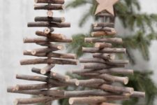 Christmas trees made of sticks with wooden stars placed on wooden slices for a rustic touch